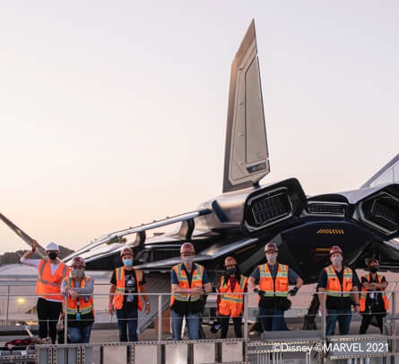 Construction workers pose in front of ongoing Avenger Campus construction.